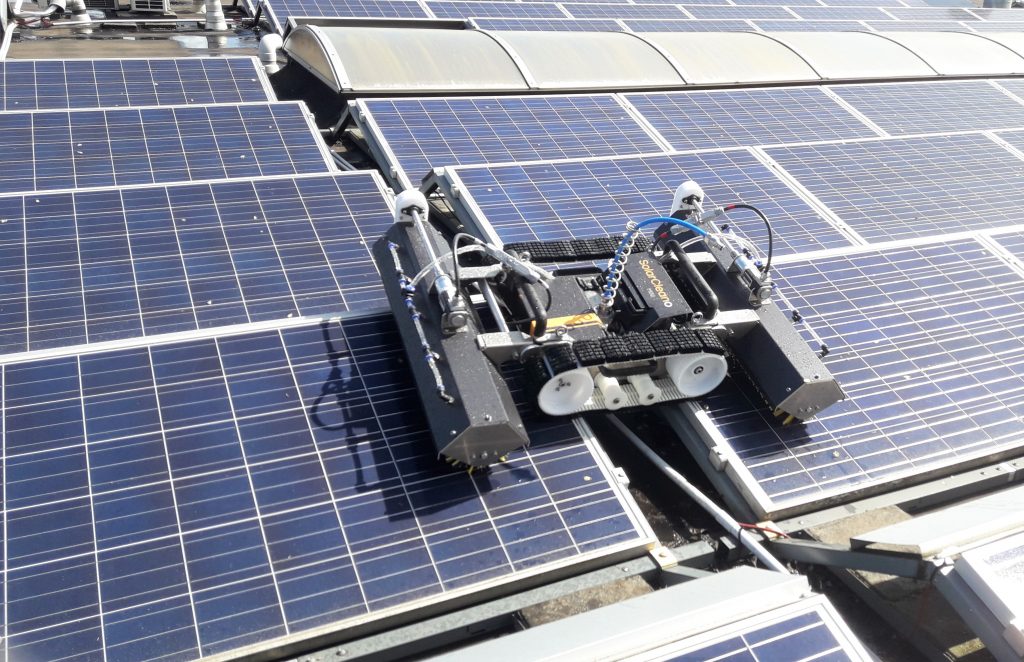 schoonmaak met mini robot zonnepanelen op plat dak